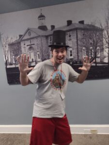 Student wearing the Lincoln hat and posing with his hands up