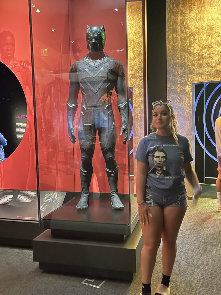 Girl in front of Black Panther suit