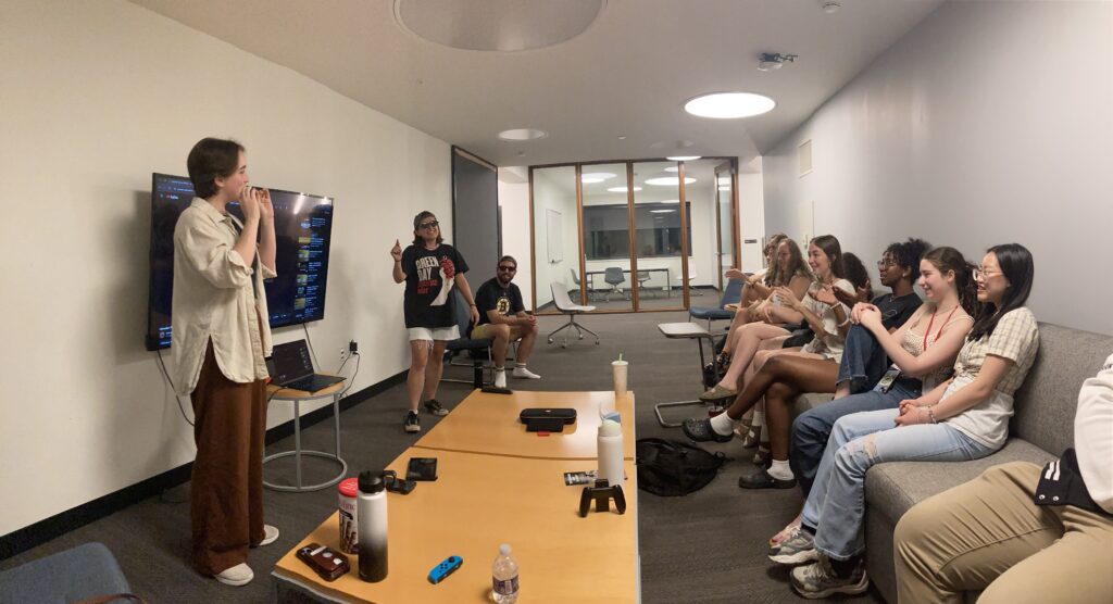 Students singing in front of a TV