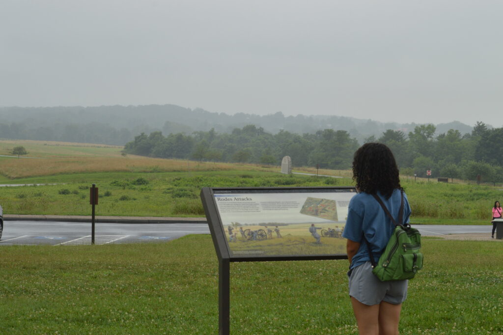 Girl reading a marker with a field in front of her