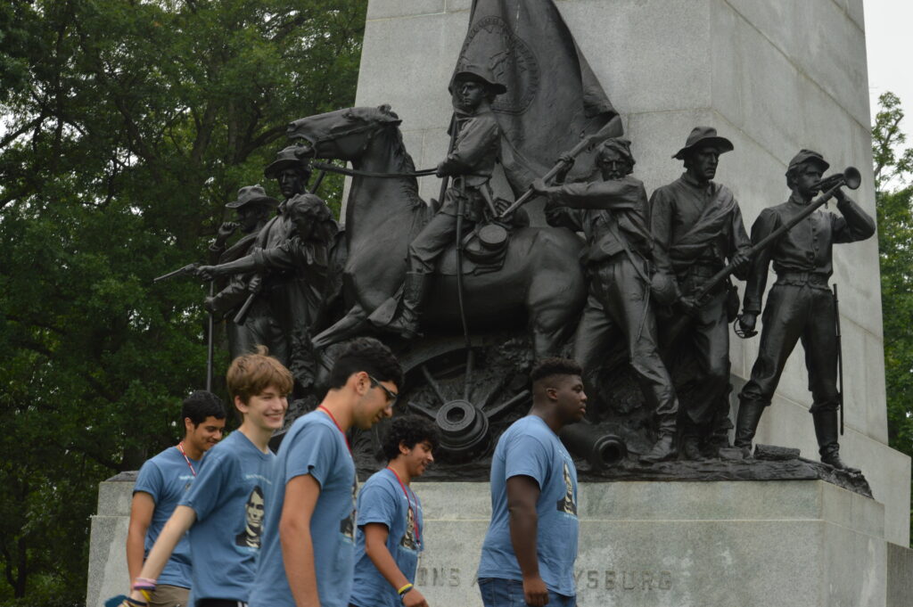 Five boys walking in front of a monument