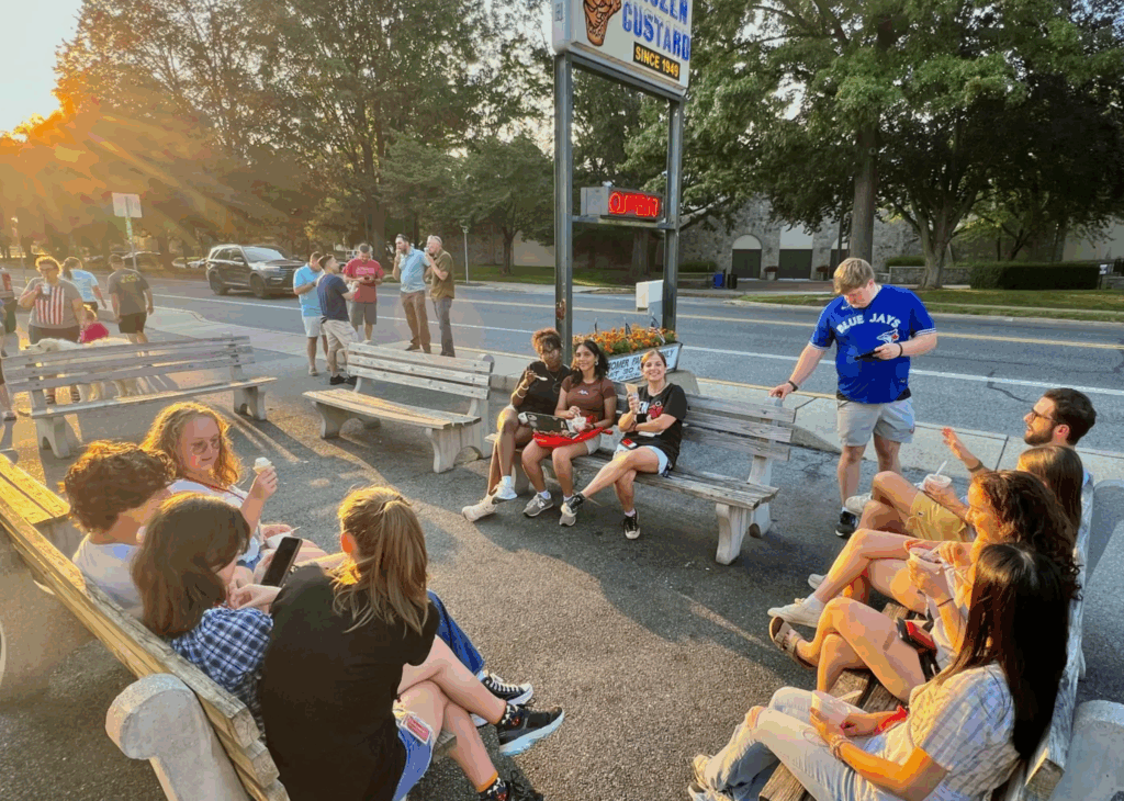 People sitting on benches eating ice cram
