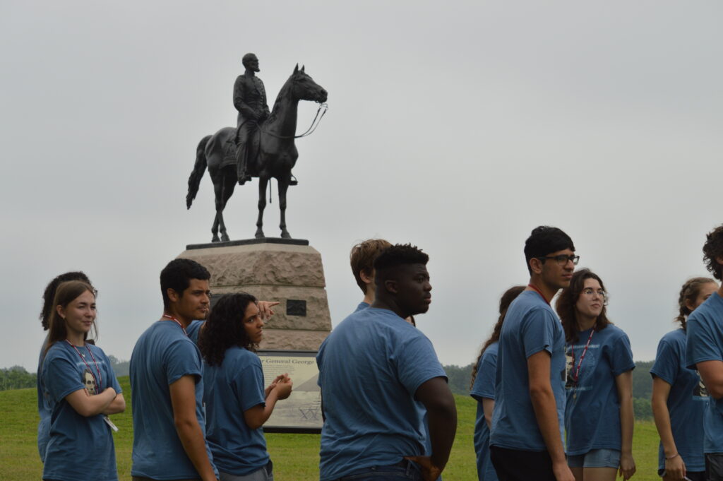 People standing in front of statue of a man on a horse