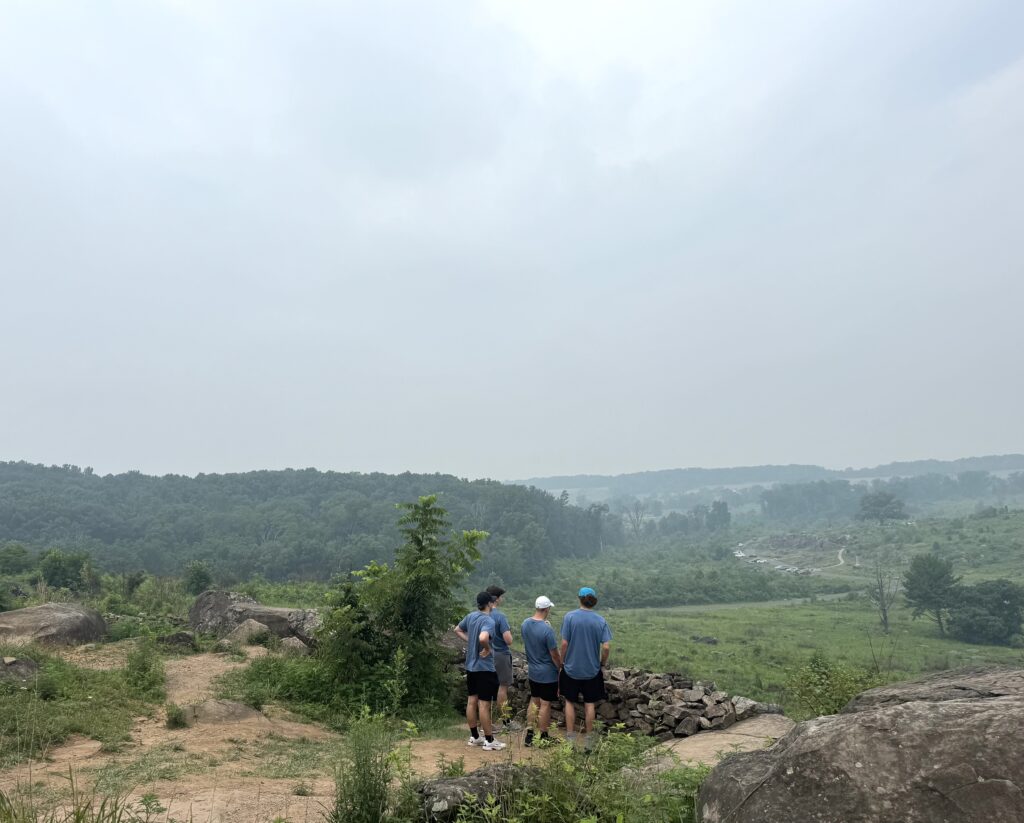 A group of students overlooking a field and hills