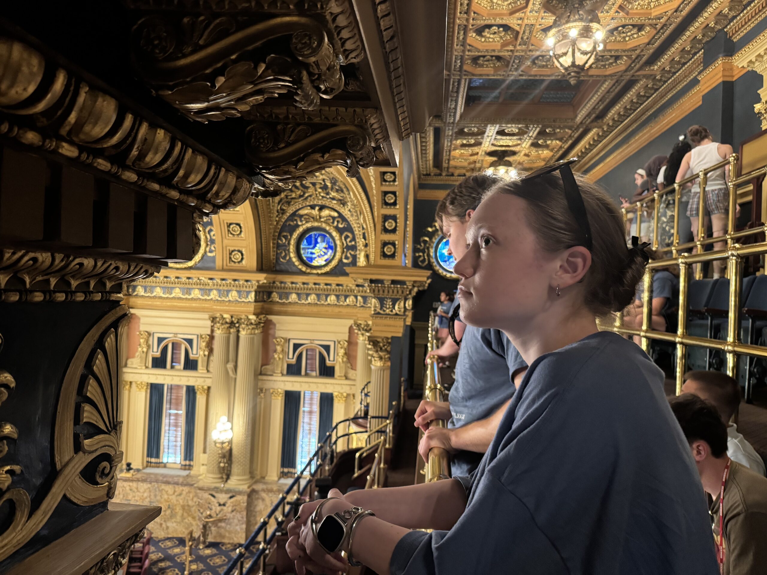 A girl sitting in a gilded room