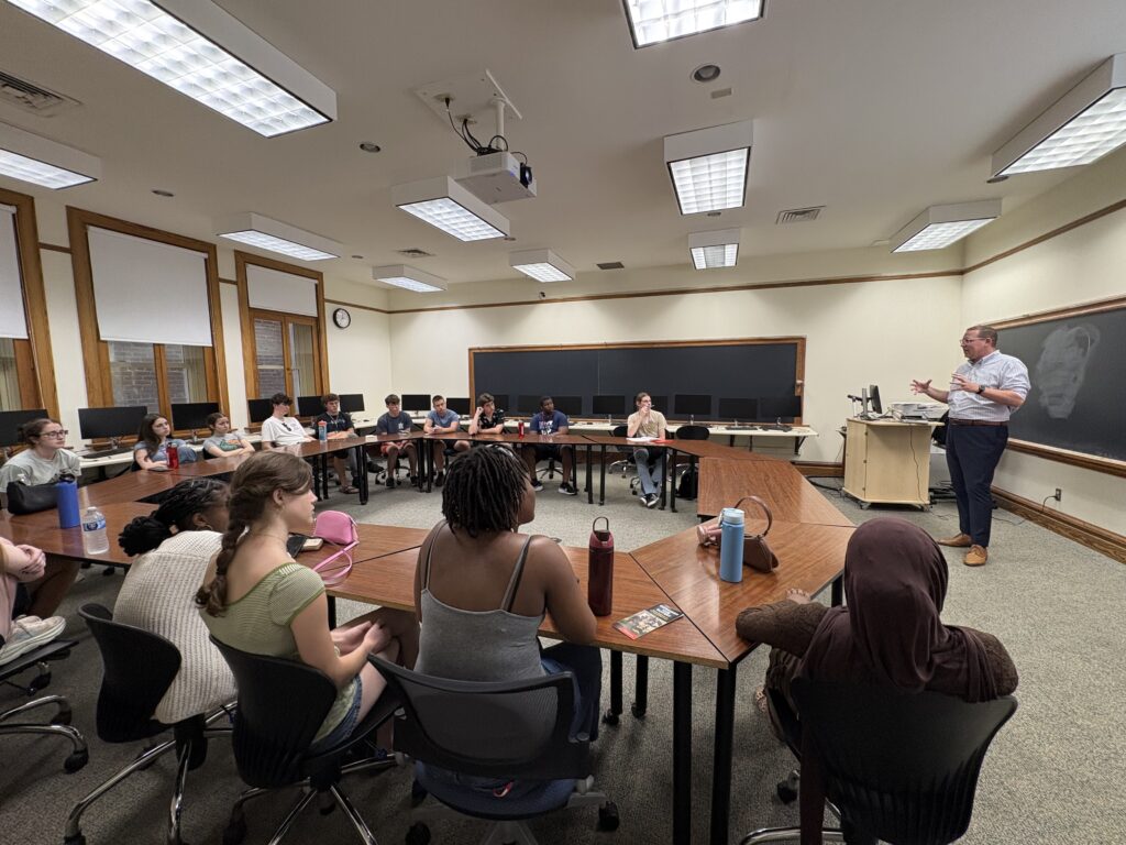 Greg Moyer standing at the front of the room, talking to the students about admissions
