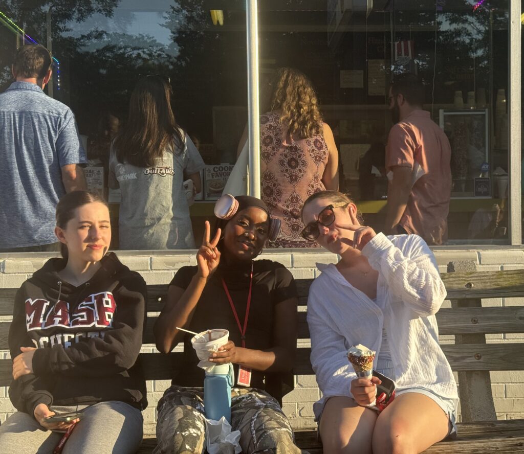 Three girls eating ice cream and smiling for the camera 