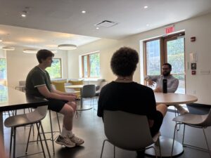 Three people sitting at a table talking.