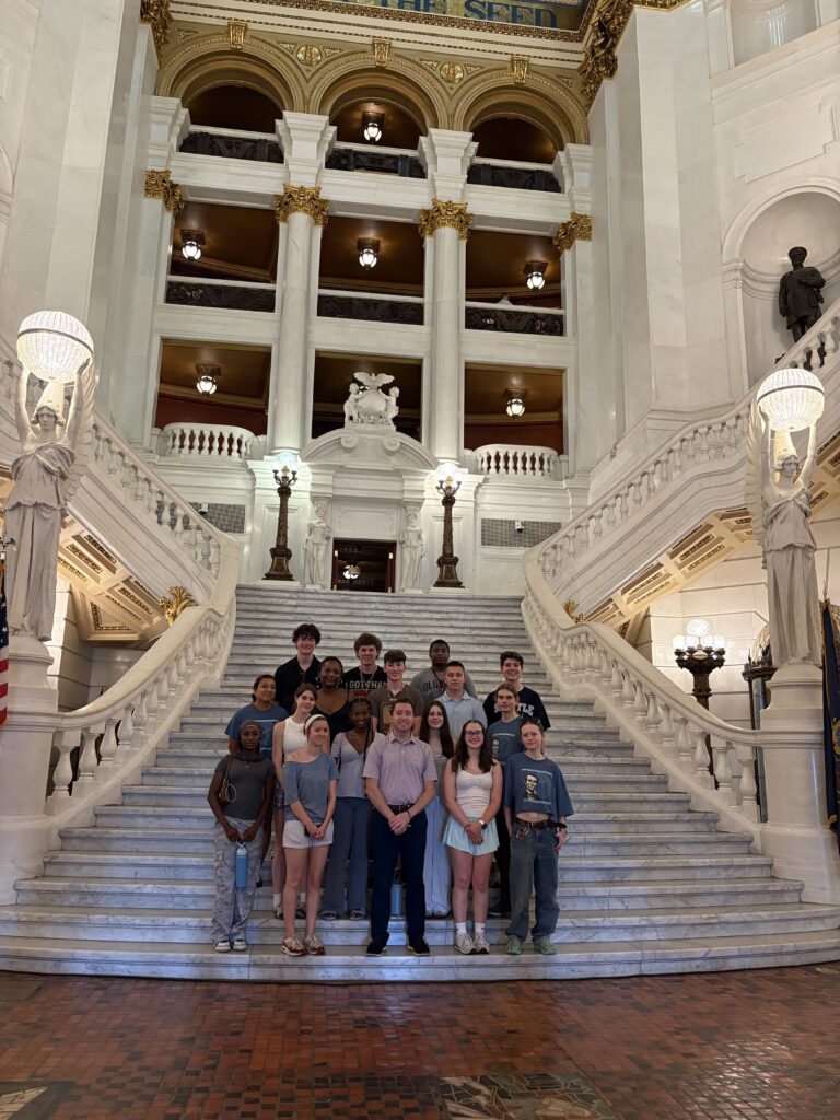A group of students standing on a marble staircase