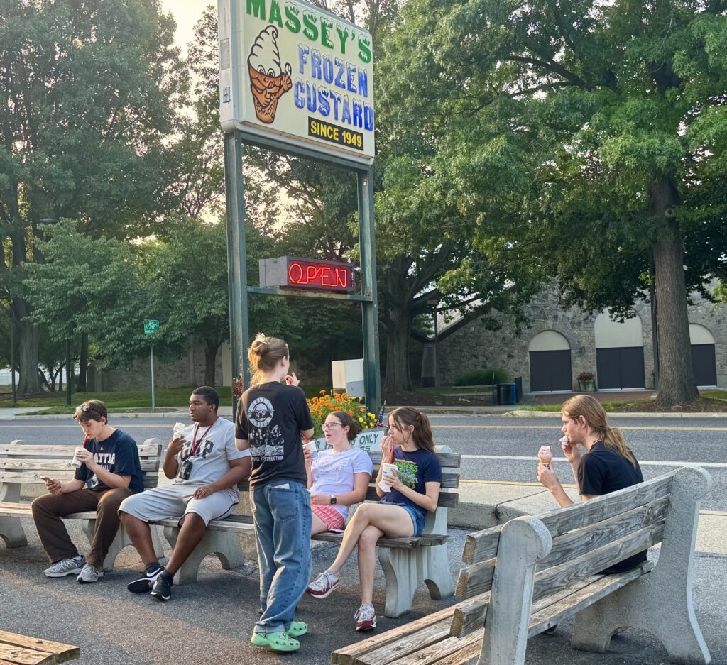 A group of students sitting on benches eating ice cream