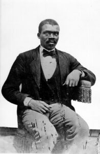 man seated in jacket with bowtie